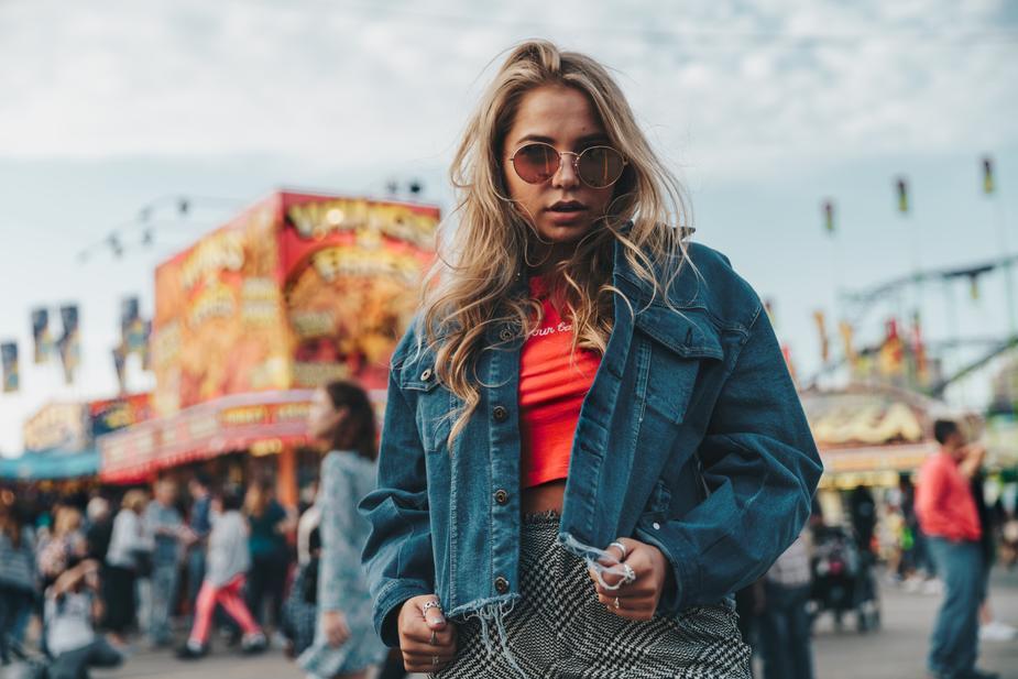 Woman wearing a denim jacket at an amusement park